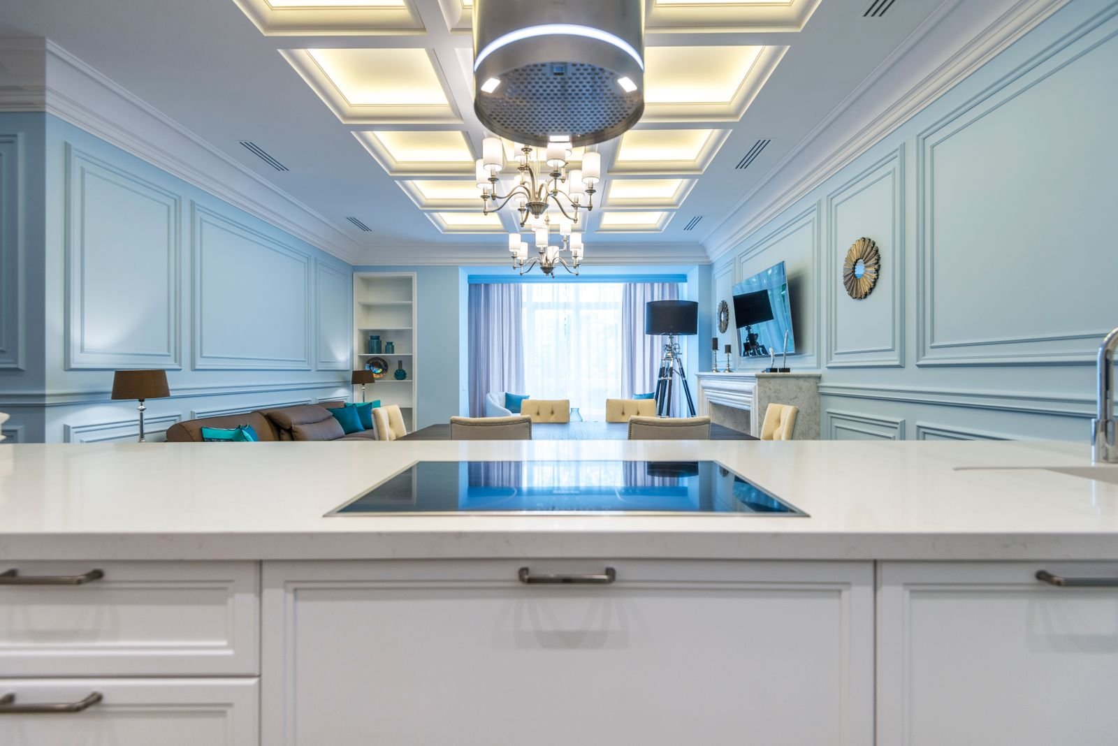An elegant interior with chandeliers and layered ceiling lighting