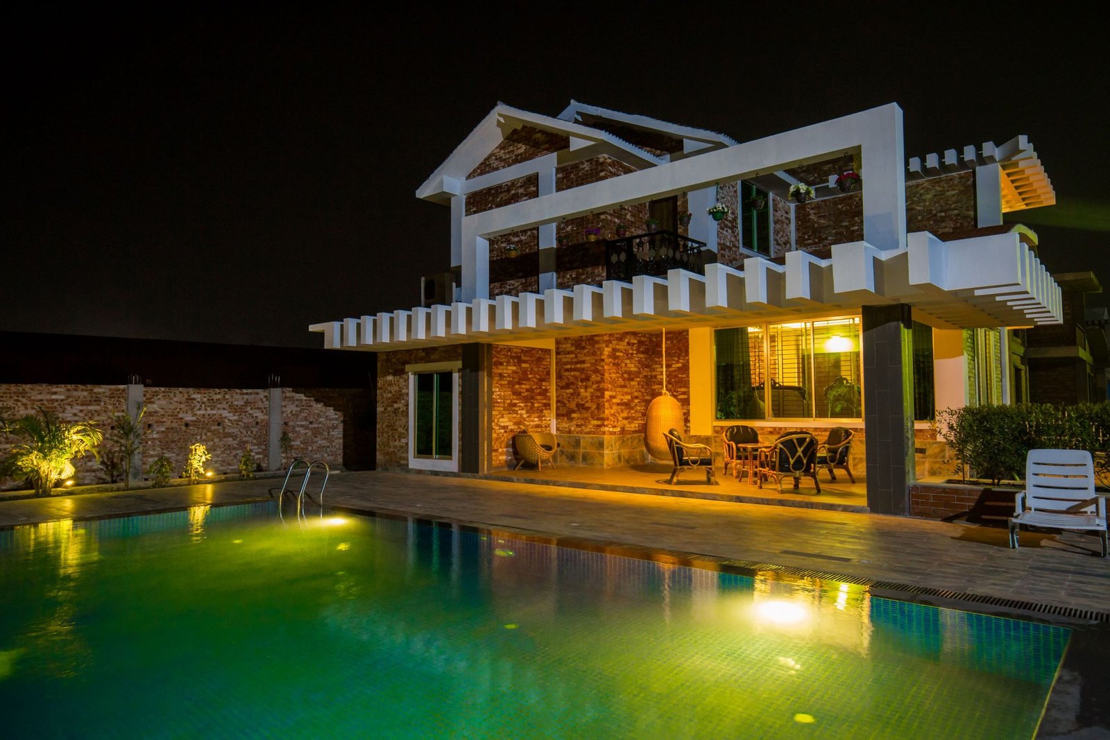 Exterior lighting bringing a home and swimming pool to life after dark