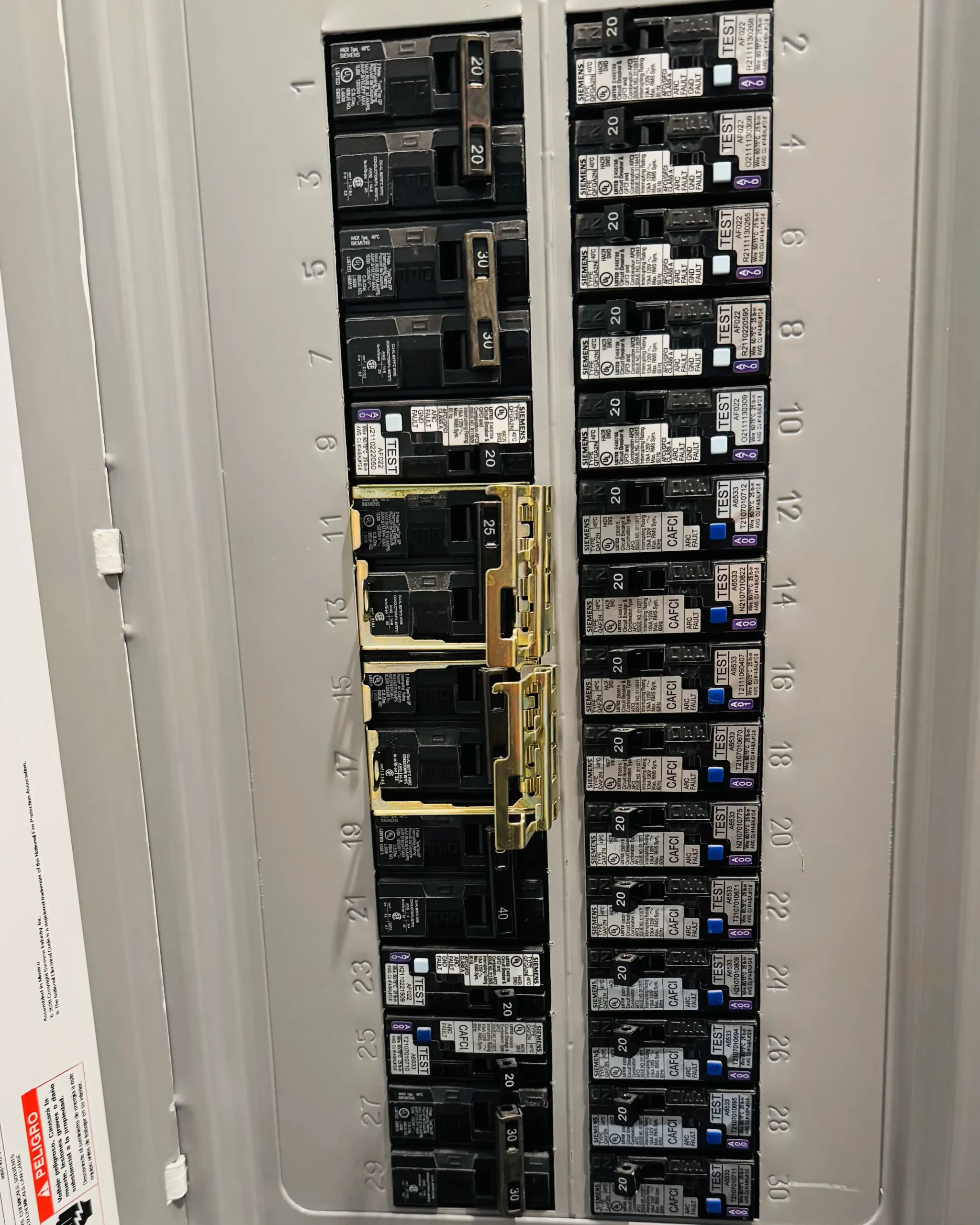 An open electrical panel with labeled breaker positions